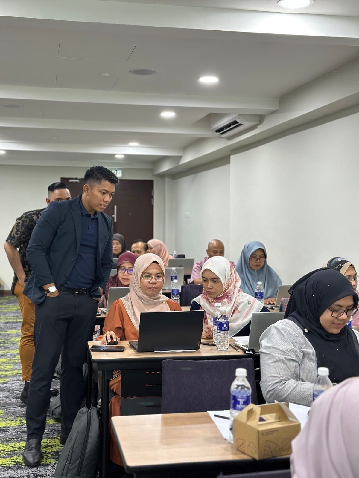 Hariz Sharif memerhati peserta membina dashboard